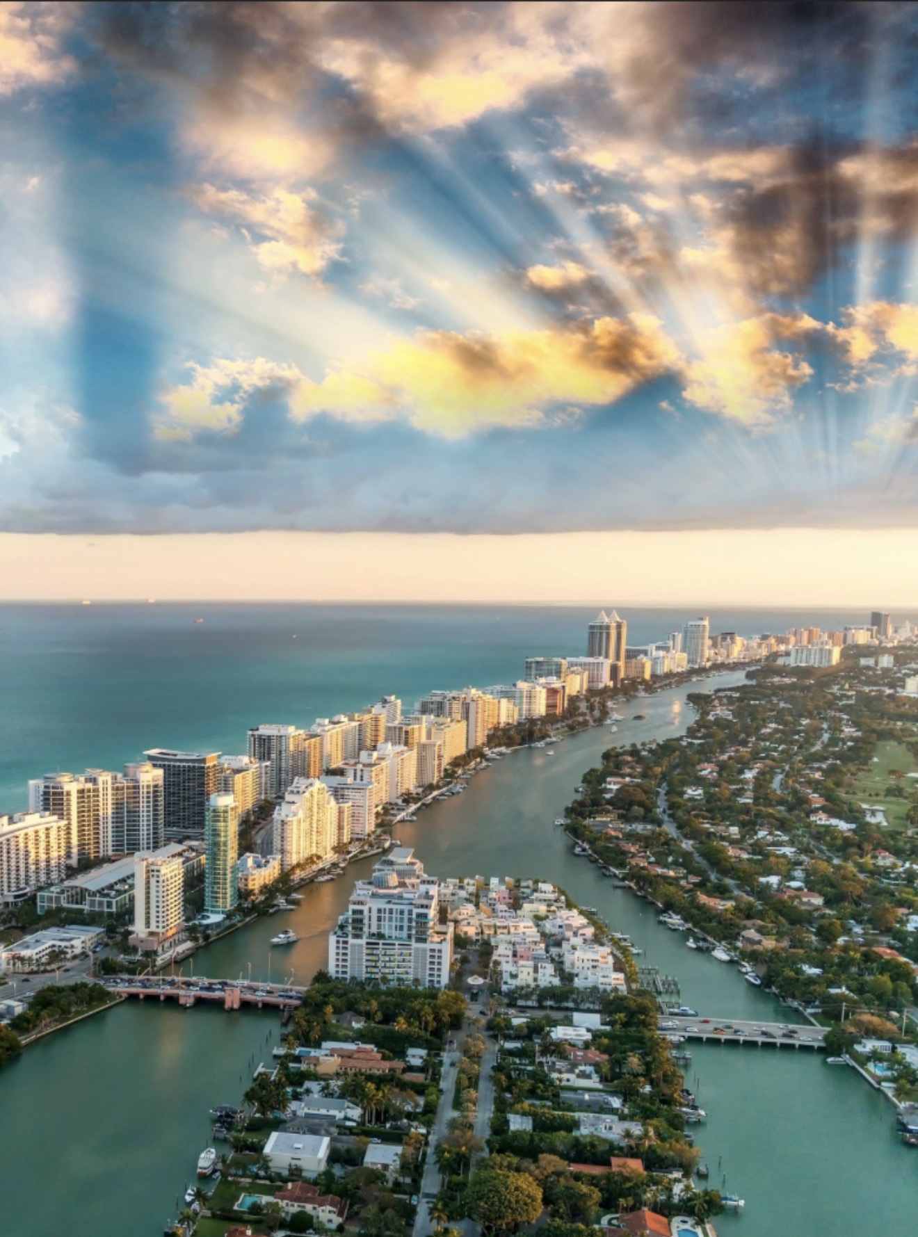 Vista aérea de Miami Beach con el canal y las casas frente al agua bajo los rayos del sol